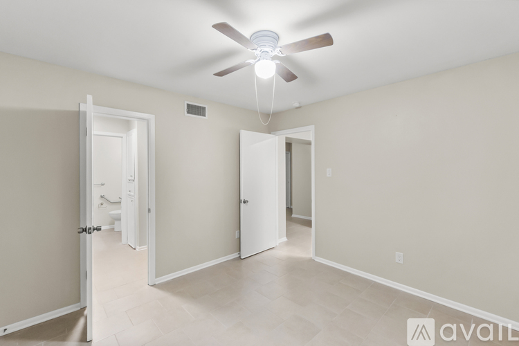 A room with a ceiling fan and two doors.