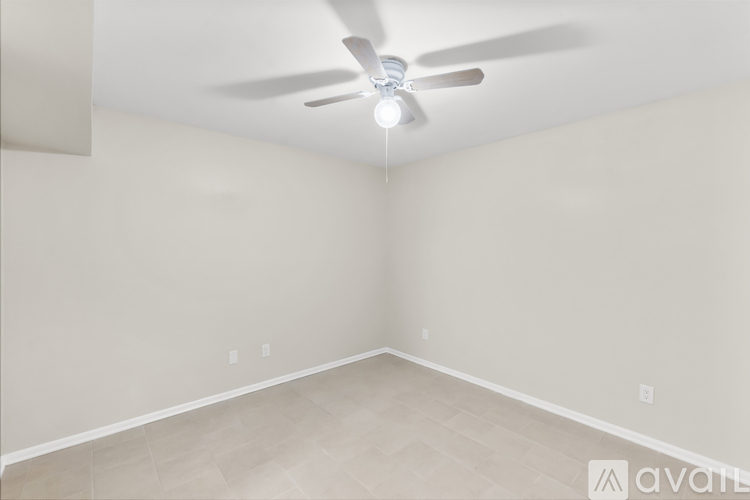 A room with a ceiling fan and light fixture.