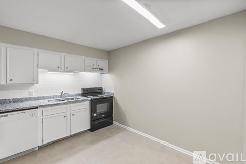 A kitchen with white cabinets and a black oven.