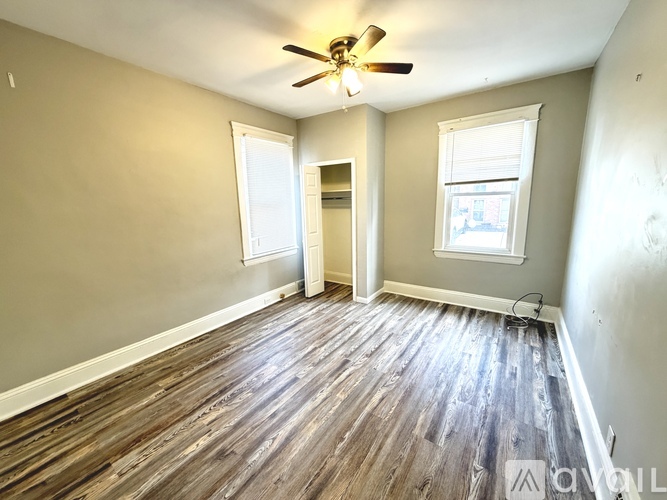 A room with wooden floors and a ceiling fan.