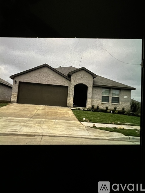 A house with a grey garage door and a brown roof.