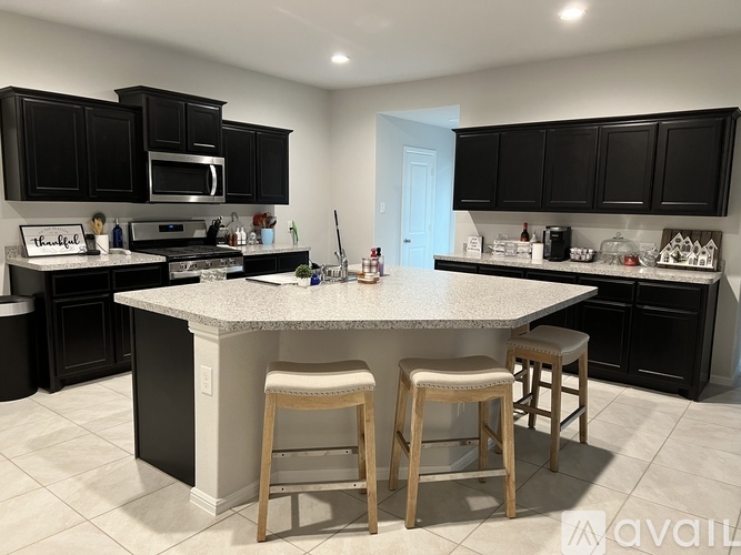 A kitchen with black cabinets and a granite countertop.