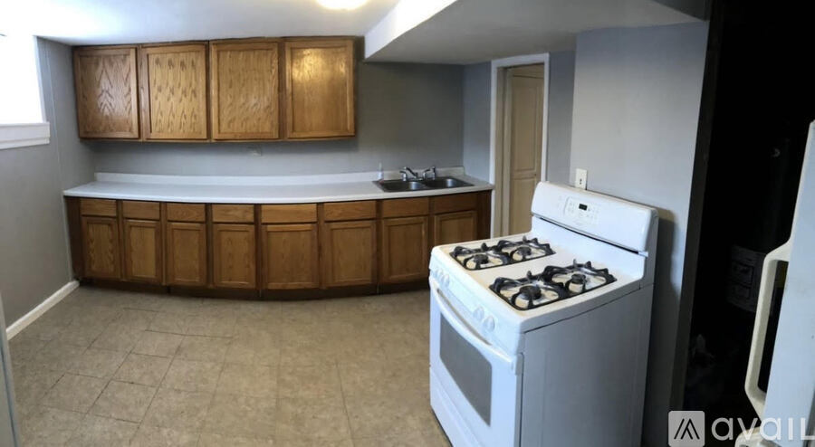 A kitchen with a white stove and wooden cabinets.