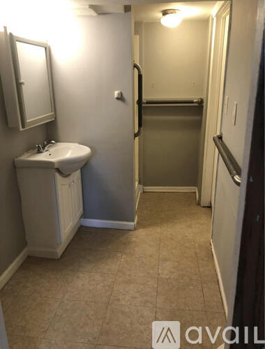 A bathroom with a sink, mirror, and towel rack.