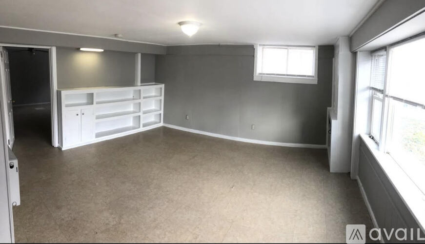 A room with a grey wall and a white door.