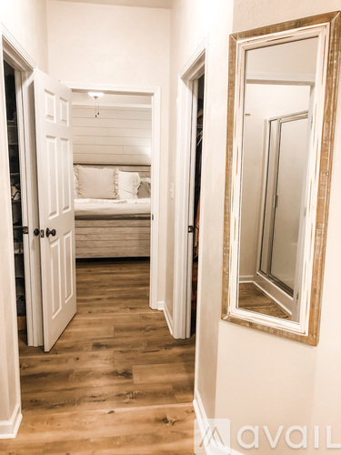 A bedroom with a bed and a mirror on the wall.