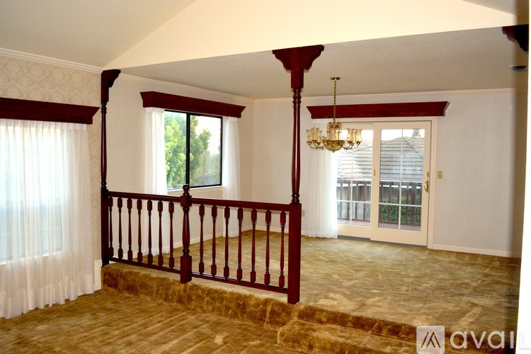 A room with a balcony and a chandelier.