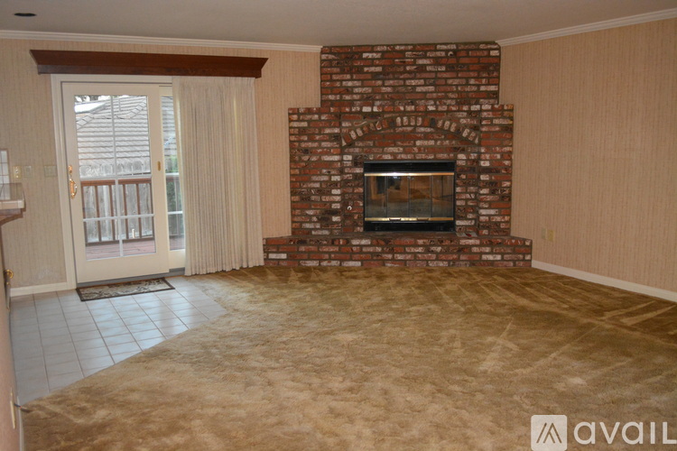 A living room with a fireplace and a sliding glass door.