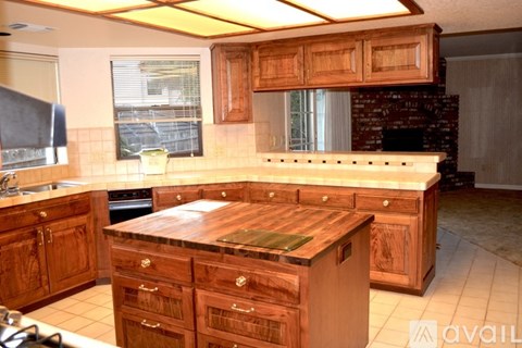 A kitchen with wooden cabinets and a brick fireplace.