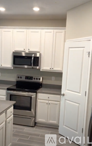 A kitchen with white cabinets and a stainless steel oven.