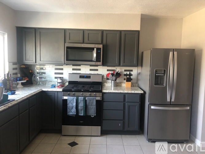 A kitchen with black cabinets and stainless steel appliances.