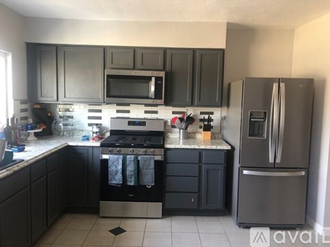 A kitchen with black cabinets and stainless steel appliances.