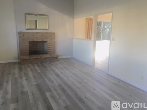 A room with a fireplace and wooden flooring.