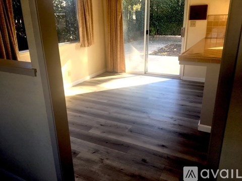 A room with wooden flooring and a sliding glass door.
