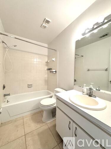A white bathroom with a toilet, sink, and bathtub.
