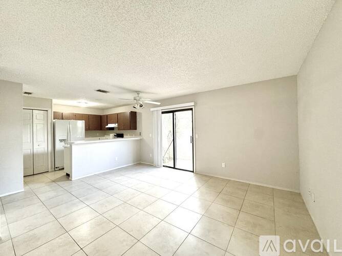 A spacious room with a kitchen area in the background.