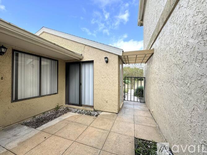 A patio area of a house with a tiled floor and a wall on one side.