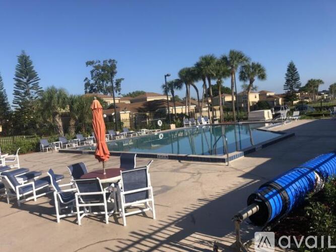 A pool area with chairs and a blue water slide.