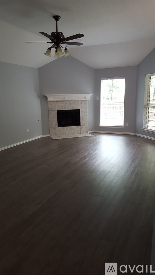 A room with a fireplace and a ceiling fan.