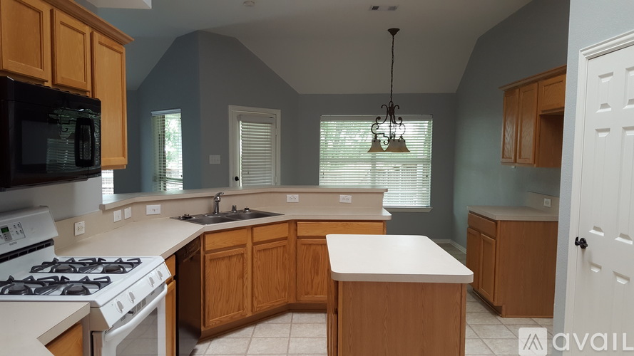 A kitchen with wooden cabinets and a white stove top oven.