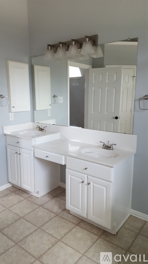 A bathroom with two sinks and a large mirror.