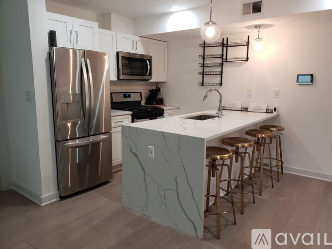 A kitchen with a marble countertop and stainless steel appliances.