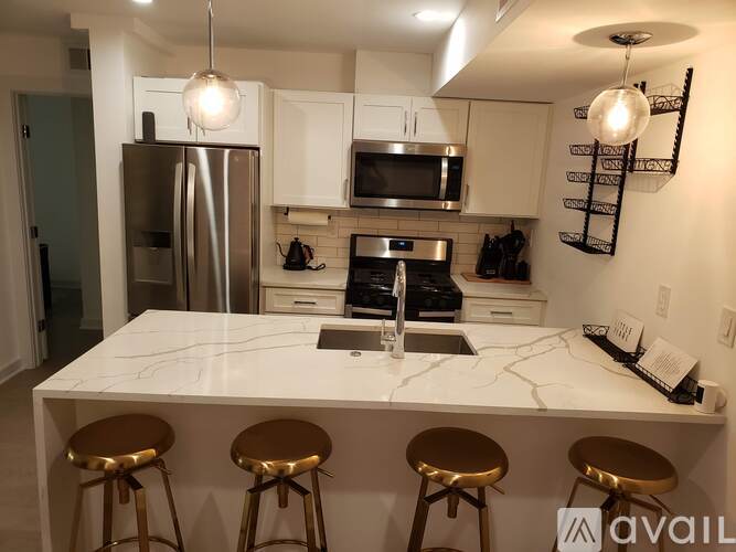 A kitchen with a marble countertop and stainless steel appliances.