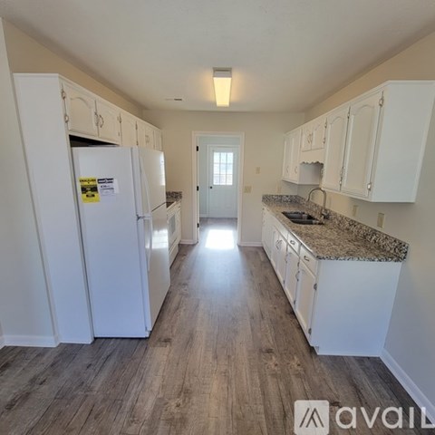 A kitchen with white cabinets and a granite countertop.