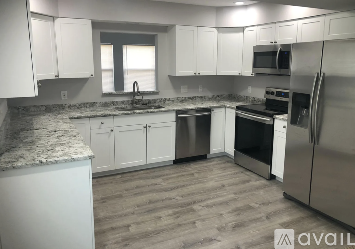 A kitchen with white cabinets and stainless steel appliances.