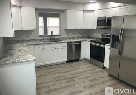 A kitchen with white cabinets and stainless steel appliances.