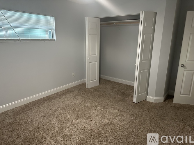 A room with a carpeted floor and a white door.