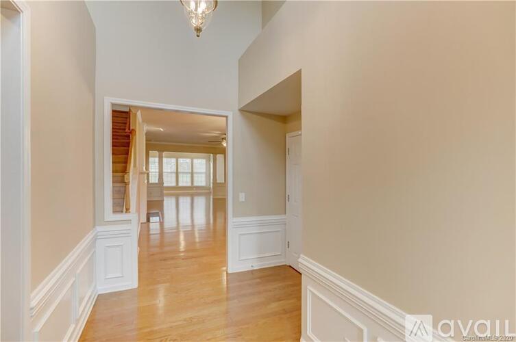 A spacious hallway with wood floors and white walls.