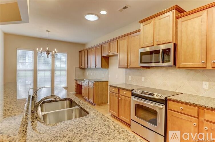 A kitchen with wooden cabinets and a stainless steel oven.