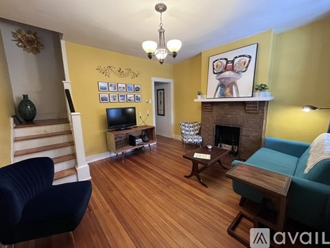 A living room with a blue chair and a fireplace.