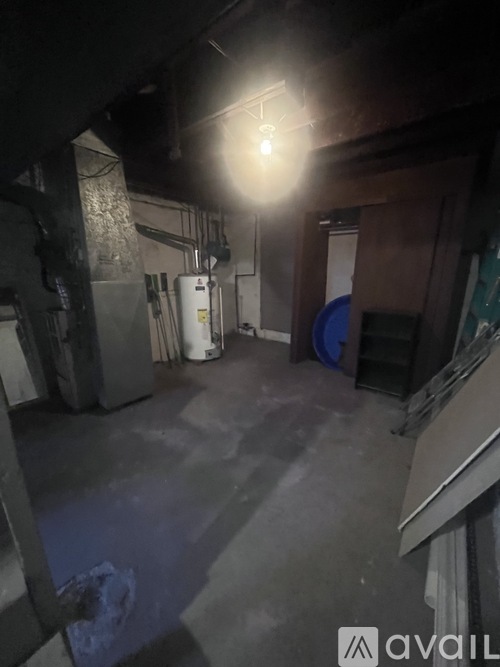 A dimly lit industrial space with a large white tank and a blue drum.