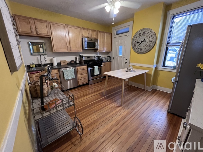 A kitchen with wooden floors and a white table.