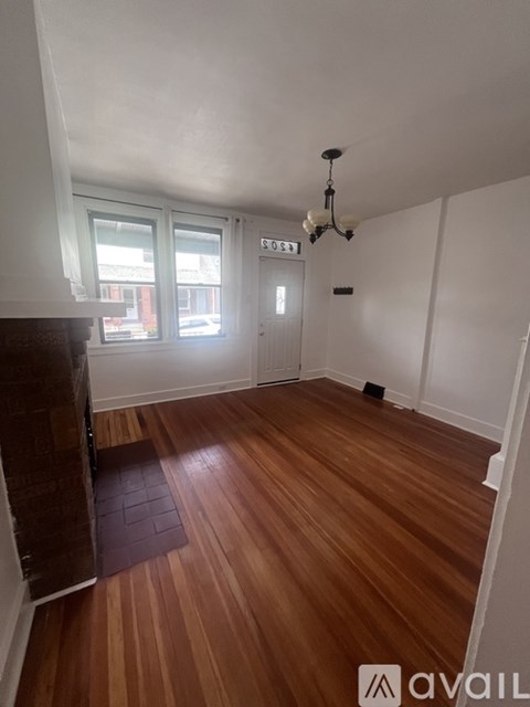 A kitchen with wooden floors and a white table.