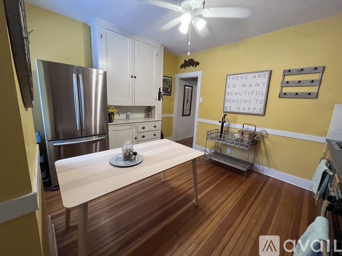 A kitchen with yellow walls and a white table.