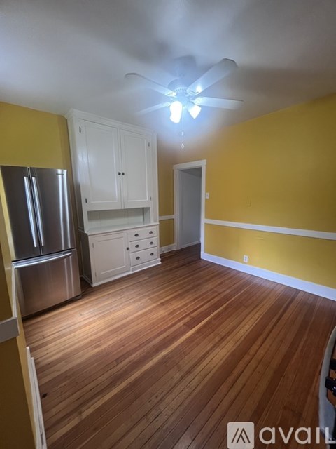 A bedroom with a bed, nightstand, and a deer head on the wall.