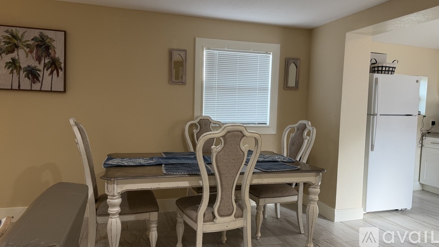 A dining room with a table and chairs.