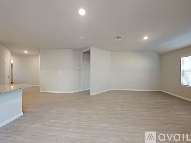 A spacious room with a marble countertop and light wooden flooring.