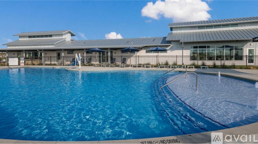 A large outdoor swimming pool with a building in the background.