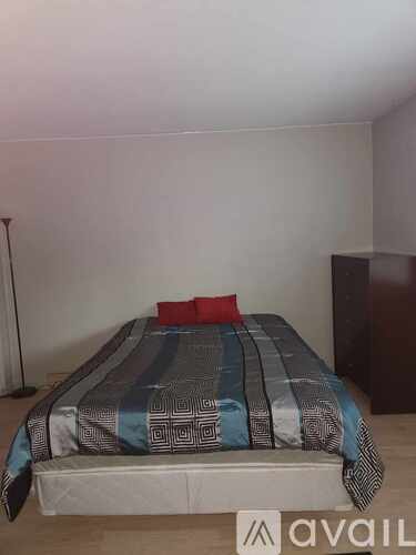 A bed with a blue and black striped comforter is in the image.
