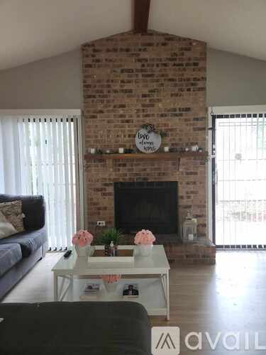 A living room with a brick fireplace and a couch.