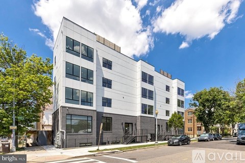 A modern multi-story building with a flat roof and large windows.