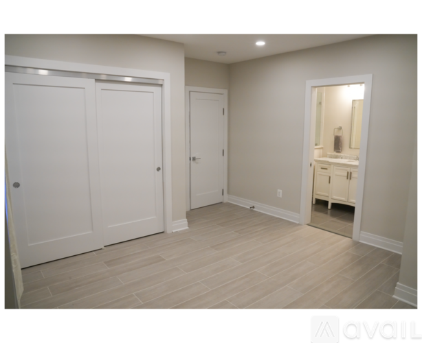 A room with white doors and a mirror on the wall.