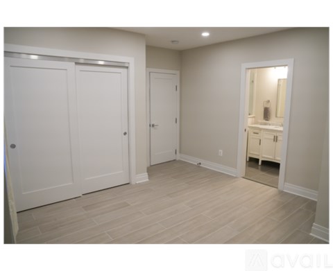A room with white doors and a mirror on the wall.