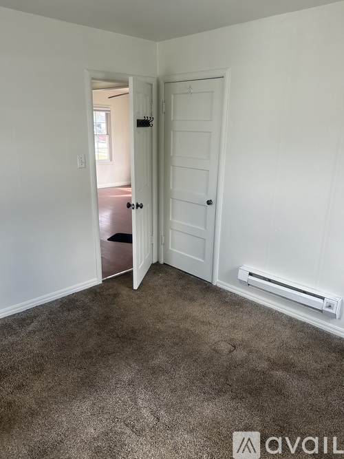 A room with a carpeted floor and a white door.