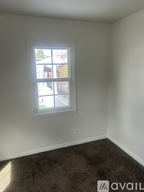 A room with a window and carpeted floor.