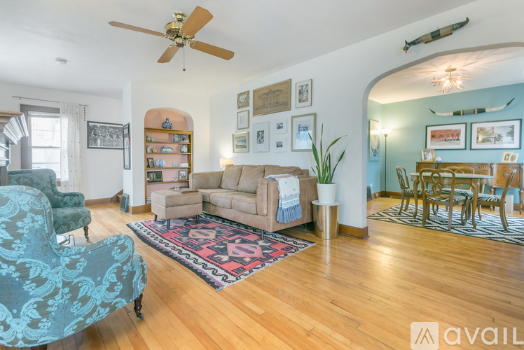 A living room with a blue patterned chair and a rug.